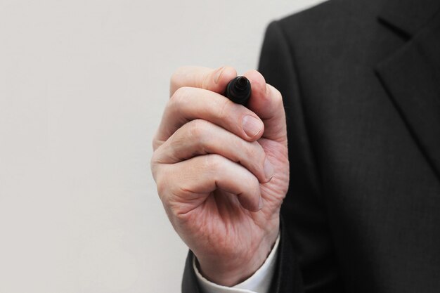 Businessman prepared to write on virtual screen or glass in office.