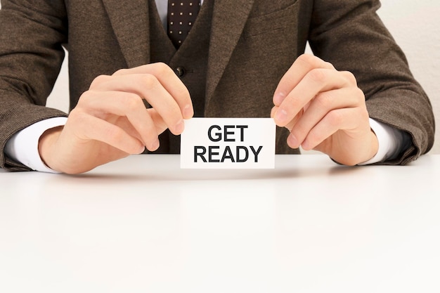 Businessman presenting 'GET READY' word on white card