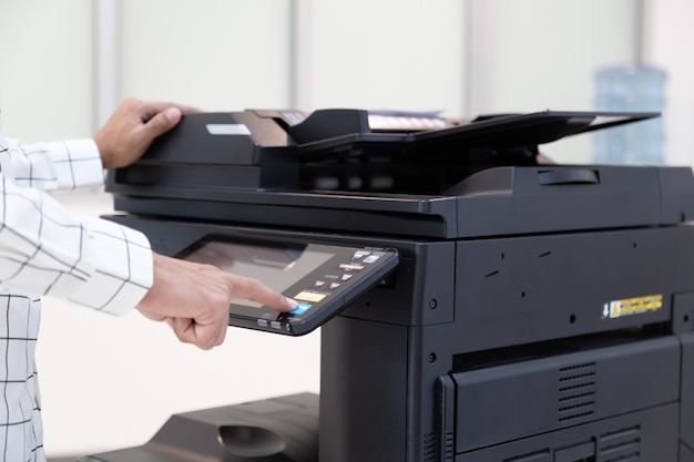 Businessman press button on panel of printer photocopier\
network working on photocopies in the office concept printer is\
office worker tool equipment for scanning and copy paper