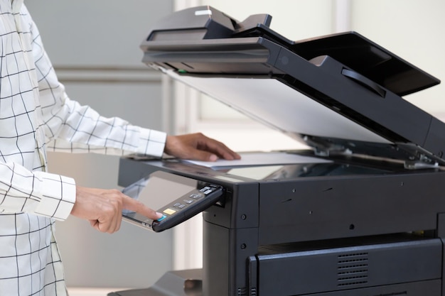 Businessman press button on panel of printer photocopier\
network working on photocopies in the office concept printer is\
office worker tool equipment for scanning and copy paper