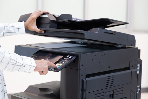 Businessman press button on panel of printer photocopier
network , working on photocopies in the office concept , printer is
office worker tool equipment for scanning and copy paper.