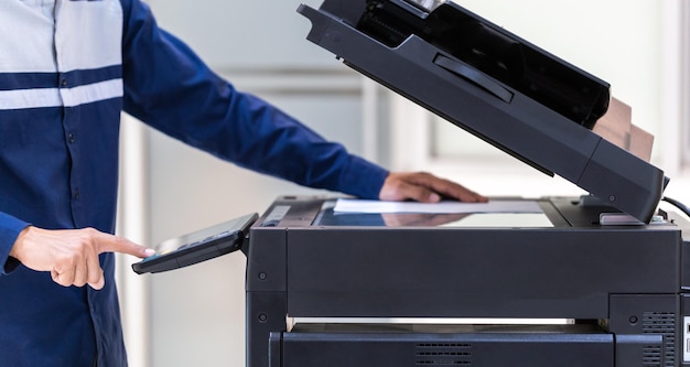 Businessman press button on panel of printer photocopier\
network working on photocopies in the office concept printer is\
office worker tool equipment for scanning and copy paper