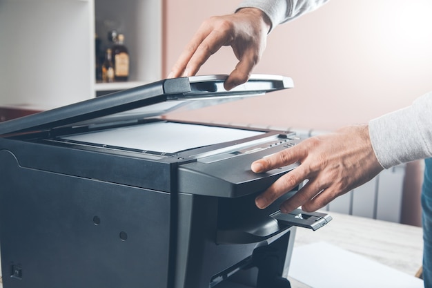 Businessman pressing button on the panel for using photocopier