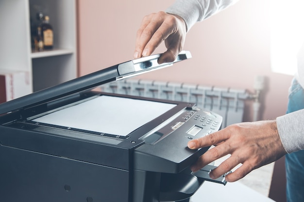 Businessman pressing button on the panel for using photocopier