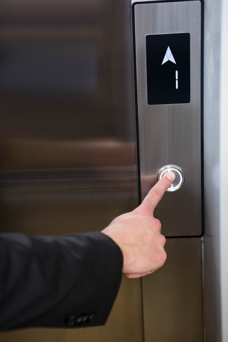 Photo businessman pressing elevator button in office