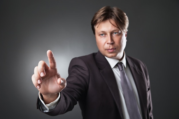 Businessman pressing an imaginary button on bokeh