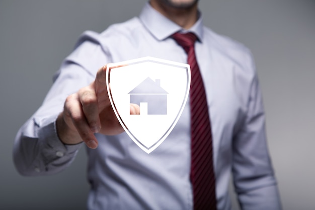 Businessman pushing on a billboard with a house. Home safety