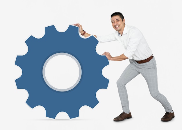 Businessman pushing a blue cogwheel