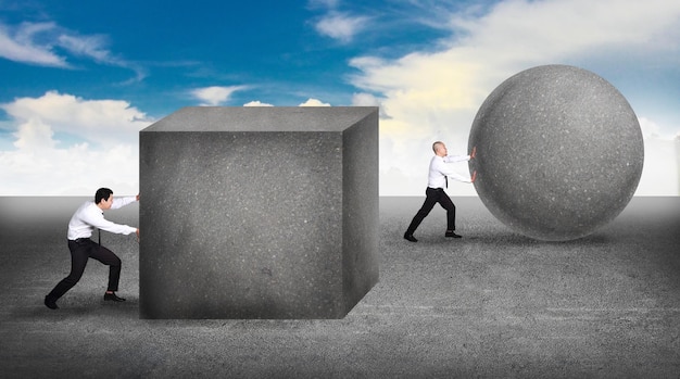 businessman pushing a sphere leading the race against a slower businessmen pushing box