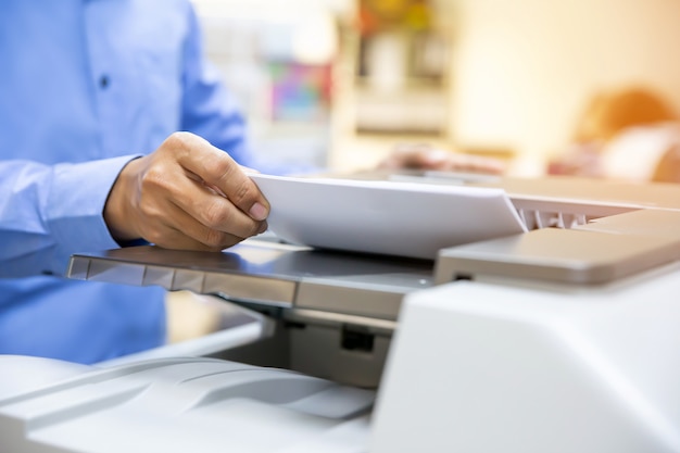 Photo businessman put the papers on the copier.