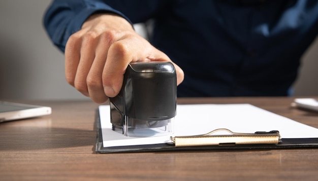 Businessman puts a stamp on the documents in the office