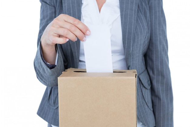 Businessman putting ballot in vote box