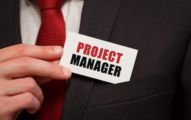 Businessman putting a card with text PROJECT MANAGER in the pocket