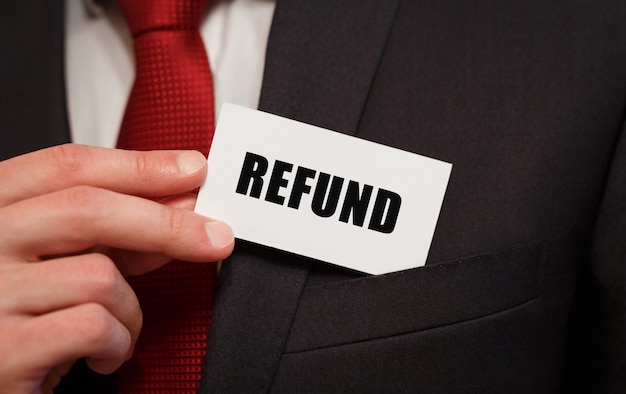 Businessman putting a card with text REFUND in the pocket