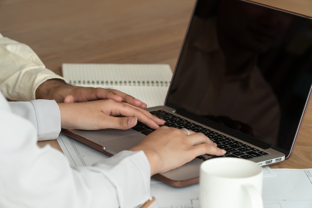 Businessman putting a hand on the hand of a female employee in office at work. Sexual harassment in workplace