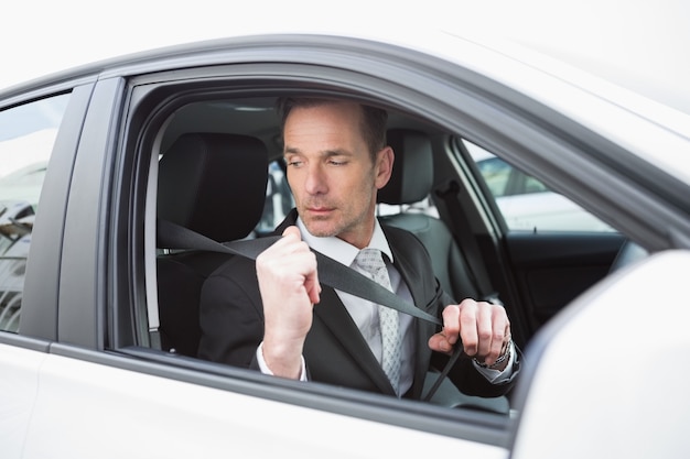 Businessman putting on his seat belt