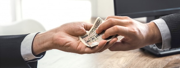 Businessman putting money in his partner hand