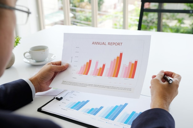 Businessman reading business information papers at office