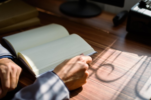 Businessman reading and writing book at work