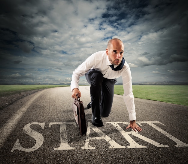 Businessman ready to run on asphalt road