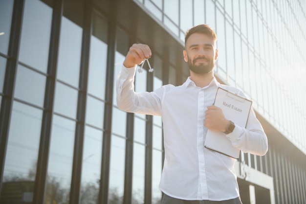 Businessman or real estate agent ready to discuss business and stands against new building