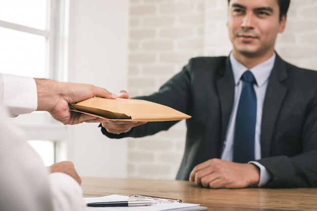 Businessman receiving an envelope after contract signing