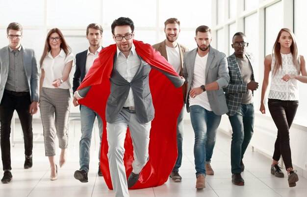 빨간 망토를 입은 사업가가 비즈니스 팀 목표 개념을 이끈다