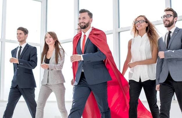 Businessman in a red cloak marching with the business team