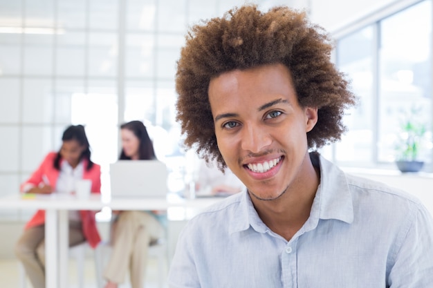 Businessman relaxing with coworkers behind him