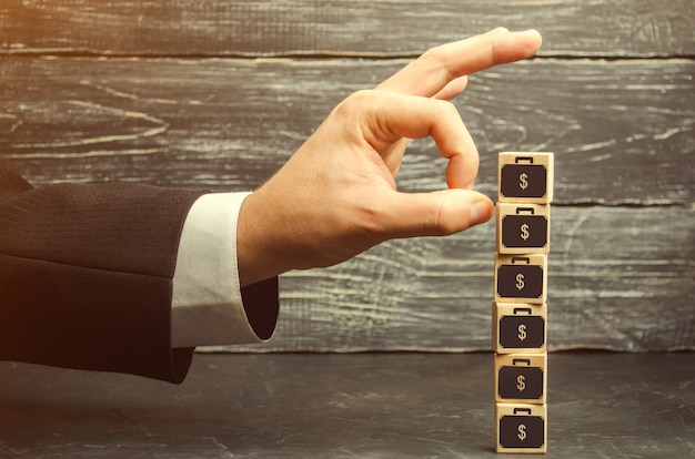 Businessman removes a cube with a picture of dollars. financial and economic crisis.