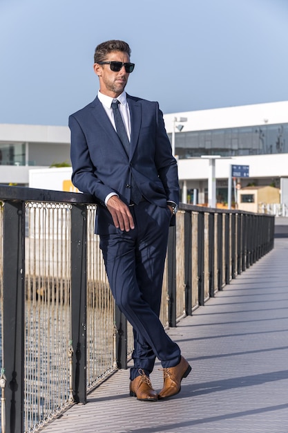 Businessman resting on footbridge near water