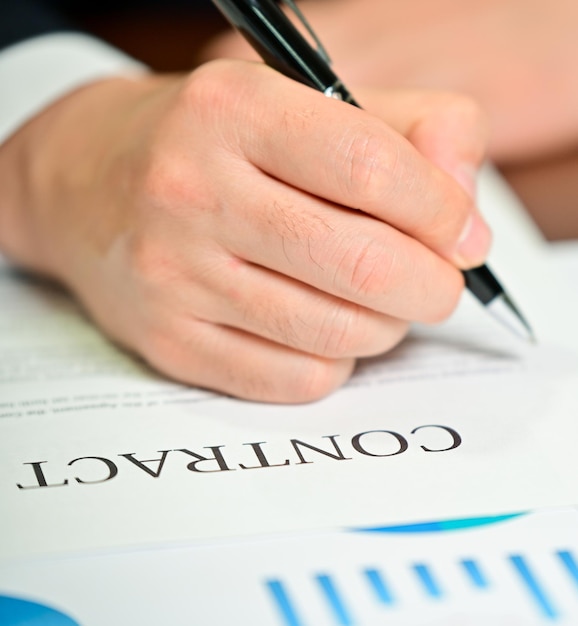 Businessman reviewing graphs and contracts on the desk