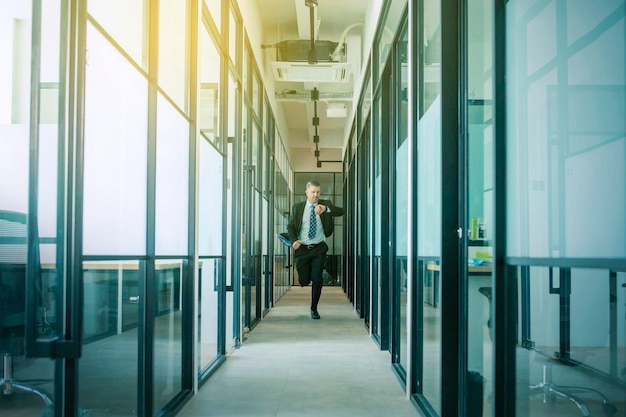 Businessman running on the hallway at sunny day