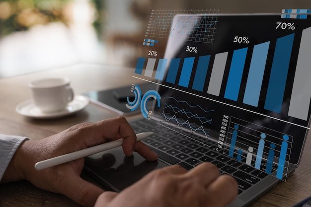 Businessman's hand graph analyzing financial graph diagram on laptop at workplace office report KPI analyst research on device technology