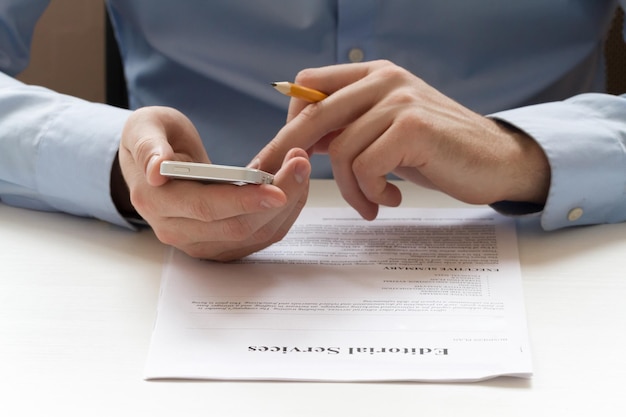 Businessman's hands holding a tablet and working with documents