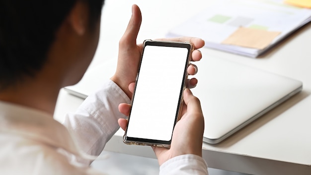 Businessman's hands using smartphone with empty screen.