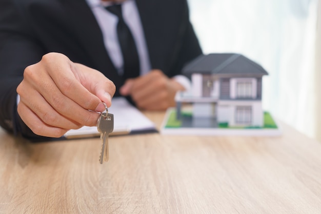 Businessman or sale man giving a house key after sign loan agreement