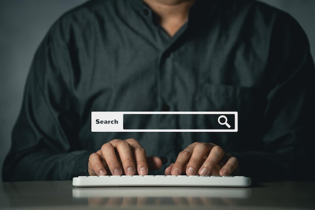 空白の検索バーでインターネットデータ情報を閲覧して検索しているビジネスマン検索エンジンの最適化SEOネットワーキングの概念オフィスの机の上でコンピューターのラップトップを操作しているビジネスマン