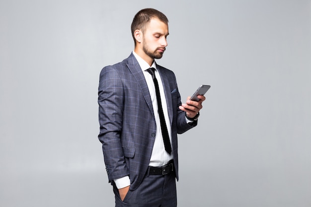 Businessman sending message in his mobile phone isolated on white background