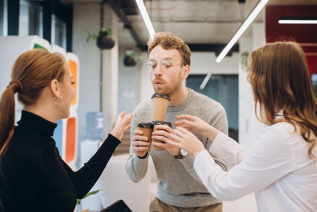 Businessman serving coffee to colleagues in office