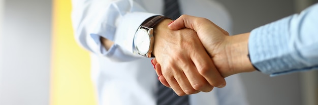 Photo businessman shakes hands with woman in office closeup.