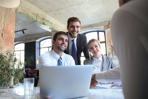 Businessman shaking hands to seal a deal with his partner and colleagues in office.