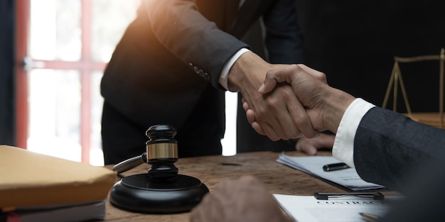 Businessman shaking hands to seal a deal with his partner lawyers or attorneys discussing a contract agreement