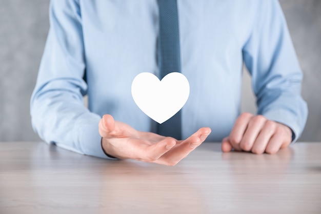 Businessman in shirt holding heart icon symbol .