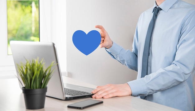 Businessman in shirt holding heart like icon symbol.