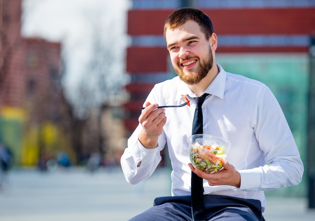 businessman in shirt and tie with salad lunch box