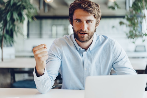 Businessman in shirt working on his laptop in an office. Open space office