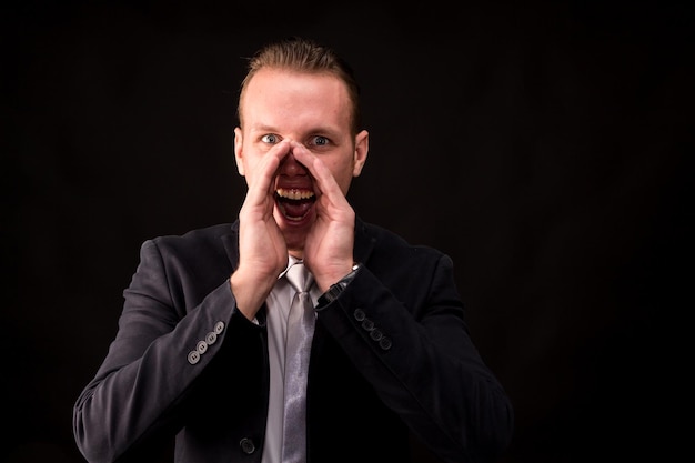 Photo businessman shouting against black background