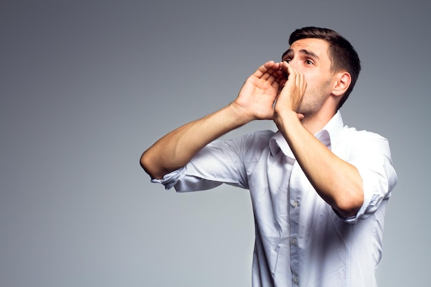 Businessman shouting over gray background