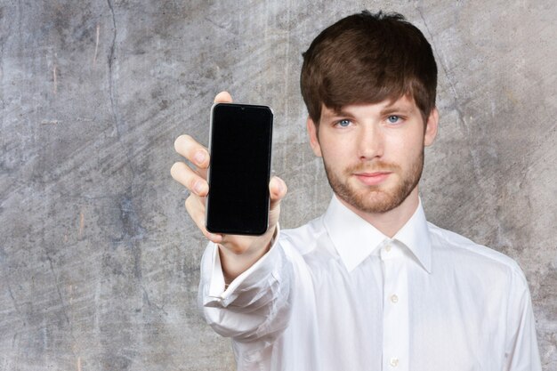 Businessman showing blank smartphone